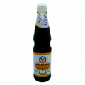Bottle of black soy sauce with a label indicating it is gluten-free on a white background.
