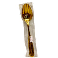Gold stainless steel serving fork and spoon set in plastic packaging on white background